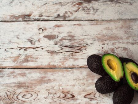 Ripe avocado cut in half on a wooden table, top view, copy spaceの写真素材