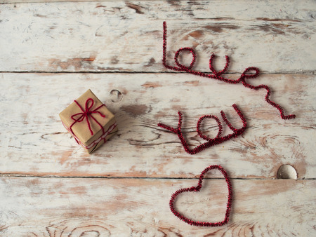 Gift for someone with I love you letters on wooden background. close up. Text space. Gift for St. Valentines Dayの写真素材