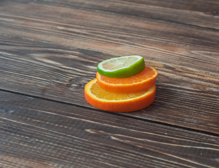 Fresh sliced oranges and lime on table, close upの写真素材