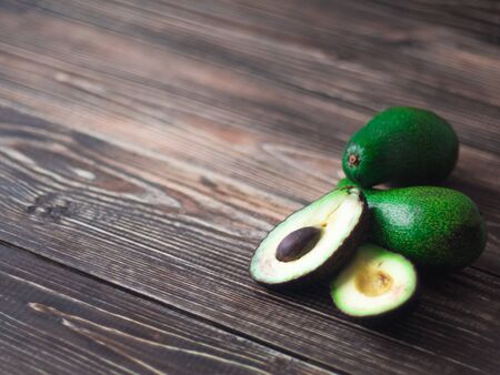Ripe avocado cut in half on a dark old wooden table, side view, copy spaceの写真素材
