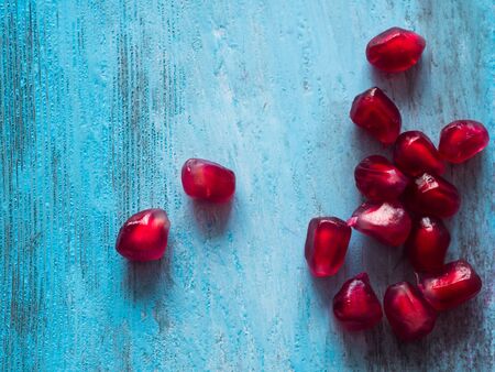 Pomegranate seeds on old wooden table. Free space for text.の写真素材