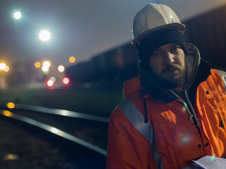 Portrait of young construction worker in helmet at night