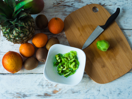 Fruits on the table top view. Kiwi, oranges and pineapple on chopping board.の写真素材