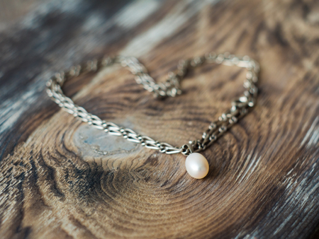 Beautiful pearl necklace heart shape on elegant wooden background. Gift concept