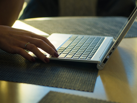 Close-up of male hands using laptop at officeの写真素材