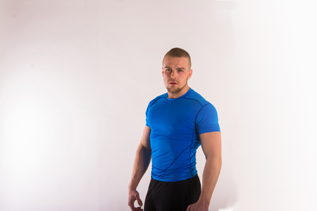 Portrait of a muscular man in sports wear standing on a white background and looking at camera. with copyspaceの写真素材