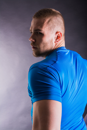 Studio portrait of an serious Muscular man in sports outfit lookingの写真素材