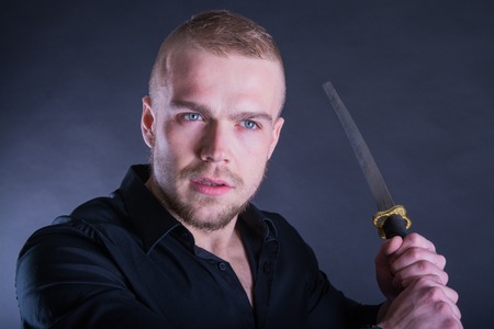 Man in black shirt with katana traditional sword. With Copy Space.の写真素材