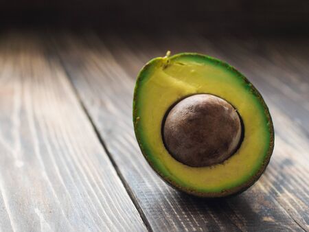 Side view of organic avocado on wooden table.の写真素材