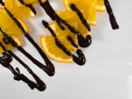 sliced ripe orange with chocolate isolated on white.の写真素材