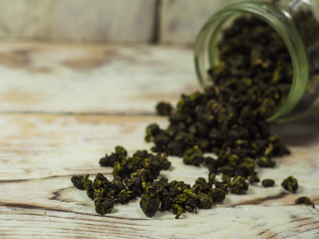 Organic wild green leaf tea on a wodden background.の写真素材