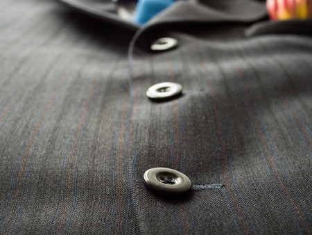 Black buttons on a man's suit background with blue tie., close up .の写真素材
