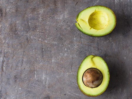Organic avocado on dark old wooden table, top view with copy spaceの写真素材