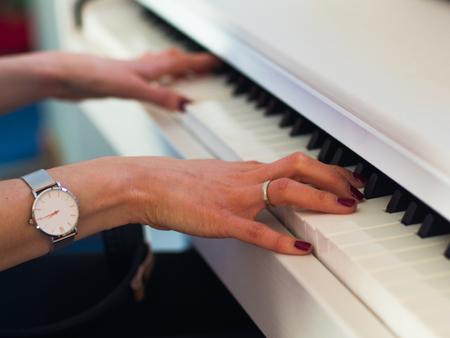Close up of the hands of a young woman playing pianoの写真素材