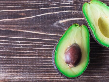 Top view on avocado slices on dark wooden table.の写真素材