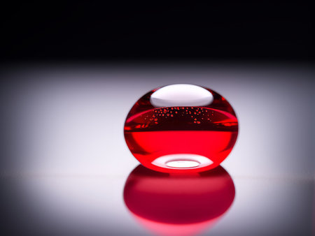 Red glass ball on a black background with reflection. Shallow depth of fieldの素材