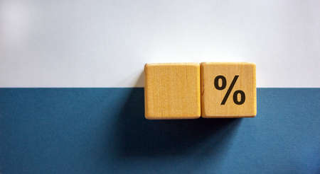 Wood cubes with word percent sign on paper blue and white background, copy space. Business concept success process.の写真素材