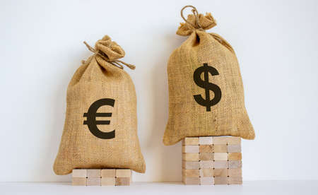 2 canvas bags with simbols of dollar and euro standing at different heights. Conceptual picture symbolizing cross currency exchange rates.の写真素材