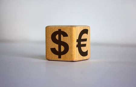 The concept of opposites, wood cube with dollar and euro signs on white background, flat lay, copy space. Conceptual picture symbolizing cross currency exchange rates.の写真素材