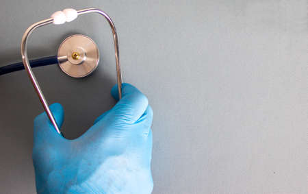 Hand in blue glove, stethoscope. Empty space for your text.の写真素材