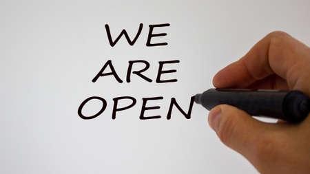 Hand writing 'we are open', isolated on beautiful white background. Concept.