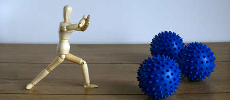 Pandemic Coronavirus concept  Wooden model of a man standing arms crossed in front of a coronavirus...