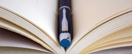 notebook and black beutiful pen on wood table