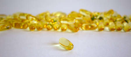 Yellow vitamins tablets, fish oil, Omega Vitamin E. Pills on a white background. Web banner with a copy space.の写真素材