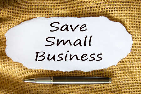 The text 'save small business' on white paper. Metalic pen. Beautiful canvas background. Business concept.の写真素材