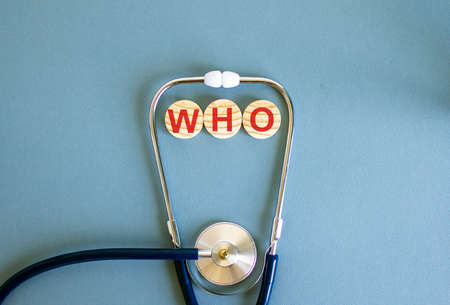 COVID-19 Pandemic Coronavirus concept. Wooden circles with the inscription WHO and stethoscope.の写真素材