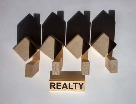 Houses created by shadows from wooden cubes. The word 'realty' on a wooden block.の写真素材