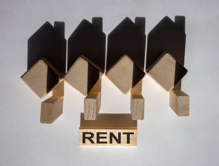 Houses created by shadows from wooden cubes. The word 'rent' on a wooden block.の写真素材