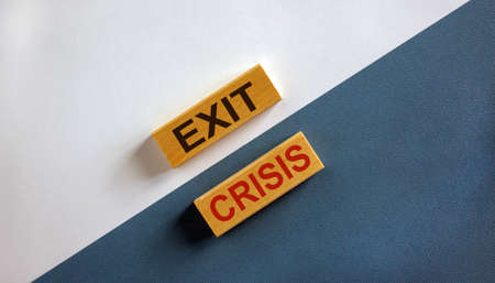 'Exit crisis' words on wooden blocks. Business concept. Beautiful white and blue background.の写真素材