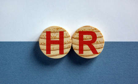 Wood circles with letteres hr on paper blue and white background, copy space. Business, employment and human resources conceptual imageの写真素材
