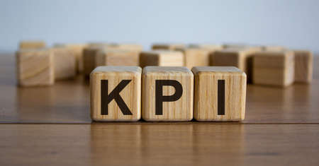 Concept word 'KPI' on cubes on a beautiful wooden table. White background. Business concept.の写真素材