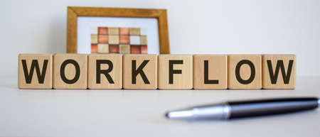 Concept word 'workflow' on cubes on a beautiful white background. Photo frame and pen.の写真素材