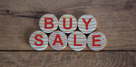 concept words buy and sale on circles on a beautiful wooden tableの写真素材