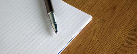 notebook and pen on wood tableの写真素材