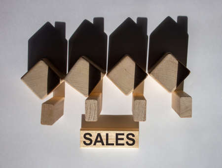 Houses created by shadows from wooden cubes. The word 'sales' on a wooden block.の写真素材