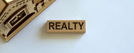 Wooden block form the word 'realty' near miniature house.の写真素材