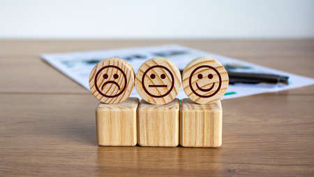 Concept sign of smiles on cubes and circles on a beautiful wooden table, pen and documents.の写真素材