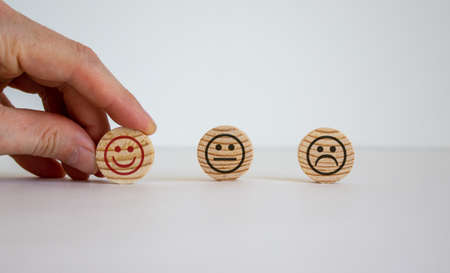 Male hand putting circle with positive smile near circles with any emotion.の写真素材