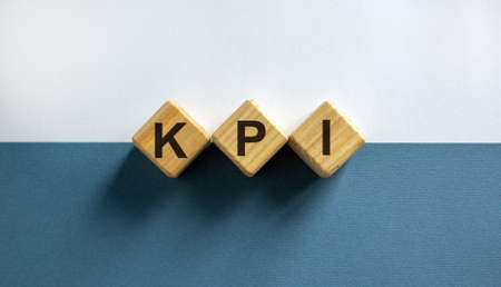 Wood cubesk with word 'kpi' on paper blue and white background, copy space. Business concept success process.の写真素材