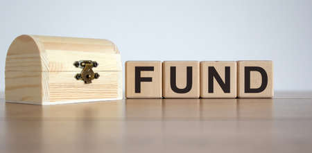 Cubes form the word 'fund' near the wooden chest.の写真素材