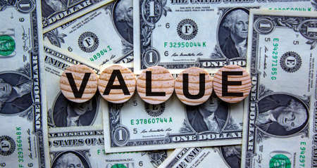 Concept word 'value' on wooden circles on a beautiful background from dollar bills.の写真素材