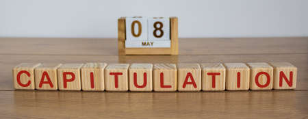 May 8 on the calendar. Victory Day. Calendar on a white background. Word capitulation on wooden cubes. The concept of one day a year.の写真素材
