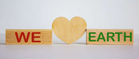'We love earth' words concept on wooden blocks. White background. Wooden hearts.の写真素材