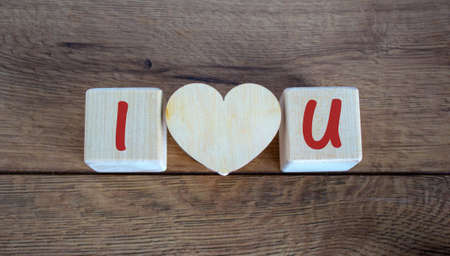 Concept letters I and U made on wooden blocks. Wooden heart.の写真素材
