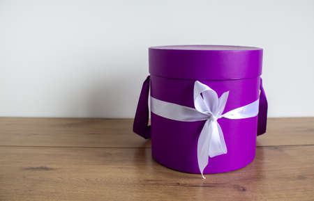 Round gift box on a wooden table on a white background. Copy space.の写真素材