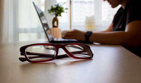 Beautiful glasses. Work from home. Business woman hands working on blank screen laptop computer on background.の写真素材